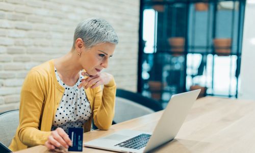 Woman holding credit card while online shopping